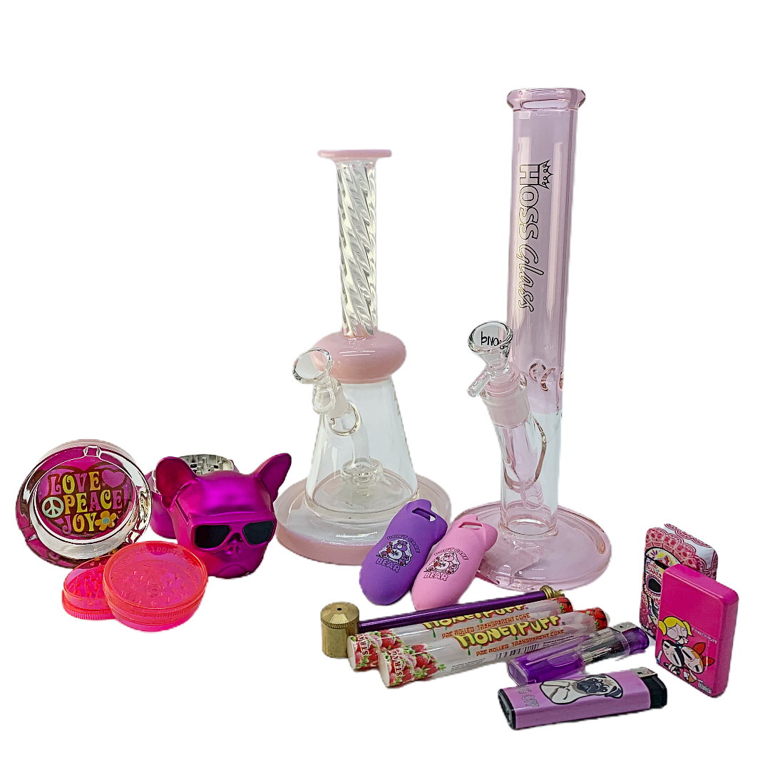 Close-up of Pink Twisted Barbie Bongs Combo surrounded by various smoking accessories on a white background.